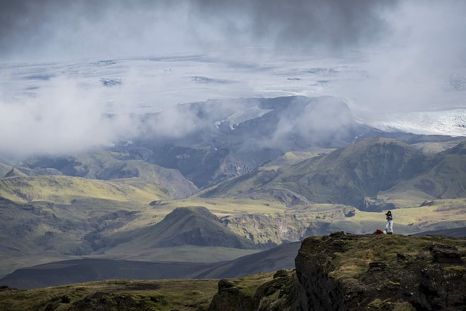 This is Iceland, person standing of mountain under cloudy sky HD wallpaper