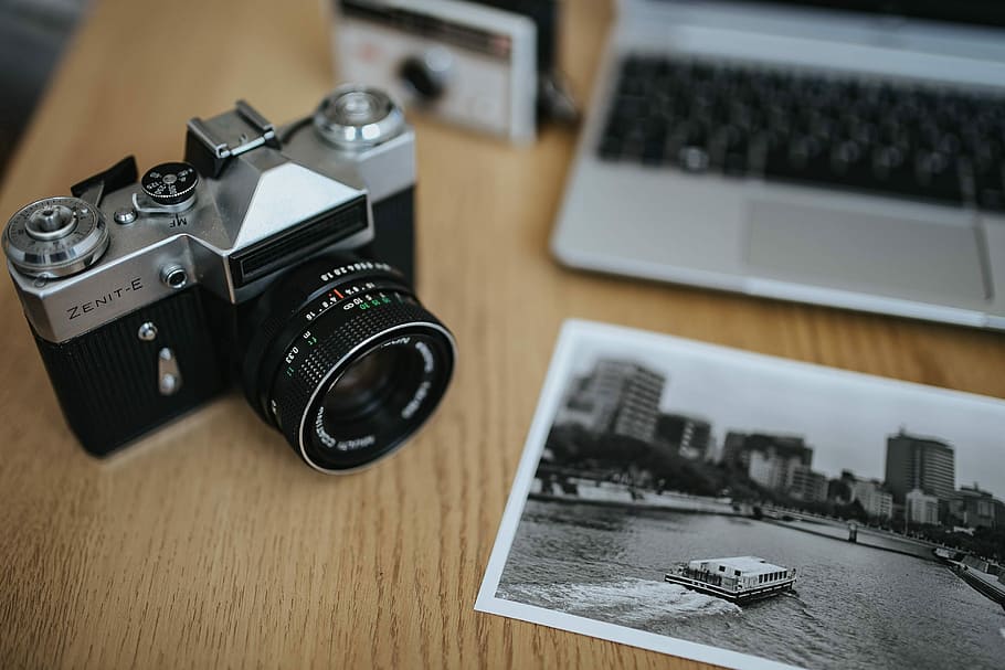 Old Zenit camera and a Canon camera with black-and-white photos on a wooden table, HD wallpaper