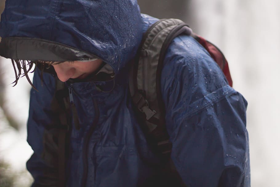 person in blue raincoat and black backpack walking with head low, person wearing blue raincoat with backpack looking downward HD wallpaper