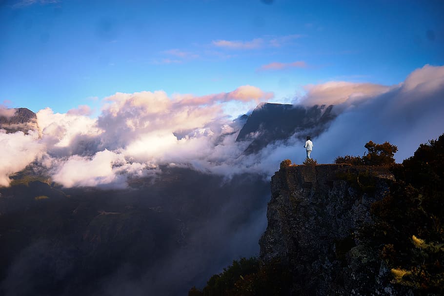 rules of third photography of gray cliff, man standing on cliff facing white clouds during daytime HD wallpaper
