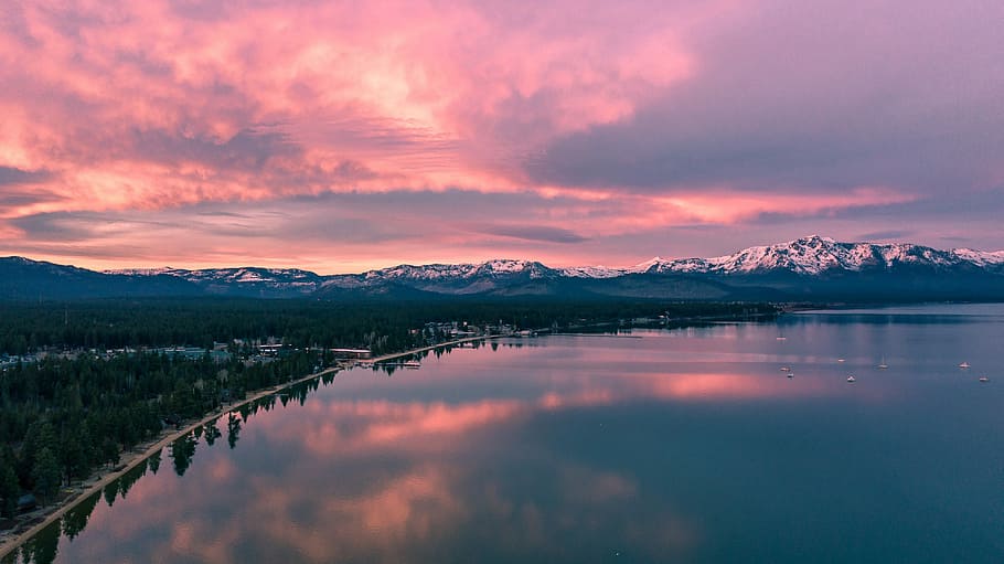 panoramic photography of body of water near mountain, city near body of water HD wallpaper