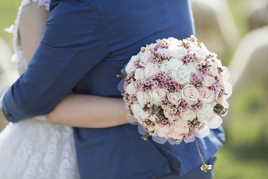 person holding rose bouquet, woman hugging man while holding pink and white rose bouquet