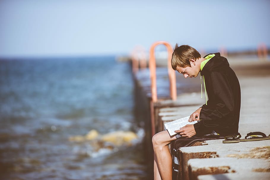 boy sitting on dock while reading, man reading books sitting on dock HD wallpaper