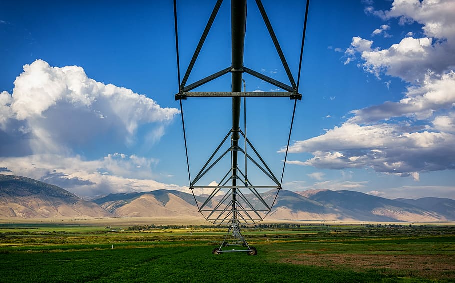 brown mountains and green grass field under white clouds during daytime, aerial view of gray electricity tower HD wallpaper