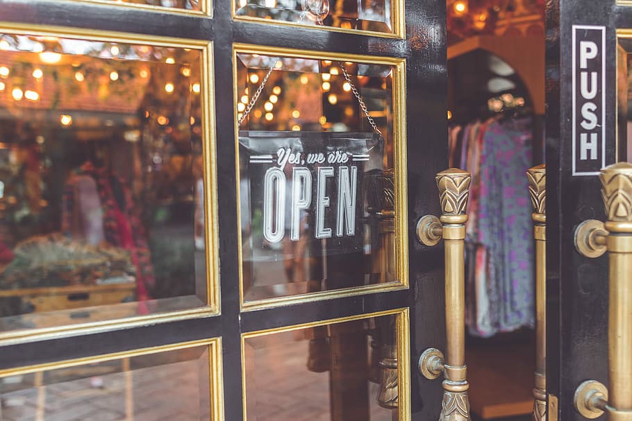Open vintage sign broad through the glass of store, slightly open black framed glass door HD wallpaper