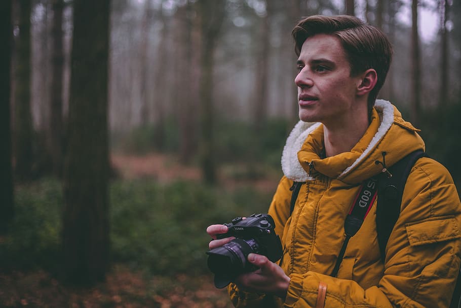 man wearing yellow parka jacket holding DSLR camera, man wearing yellow jacket holding DSLR camera HD wallpaper