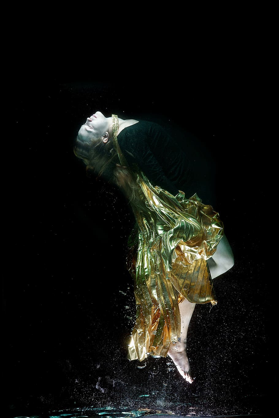 photography of woman in black dress while looking up, underwater