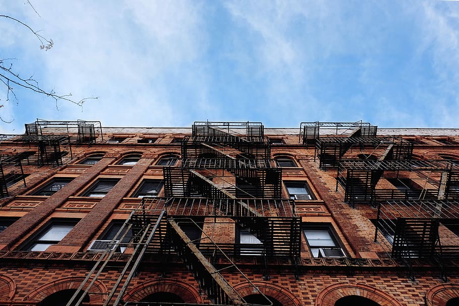 worm's-view photo of brown concrete building, black steel railings beside brown building HD wallpaper
