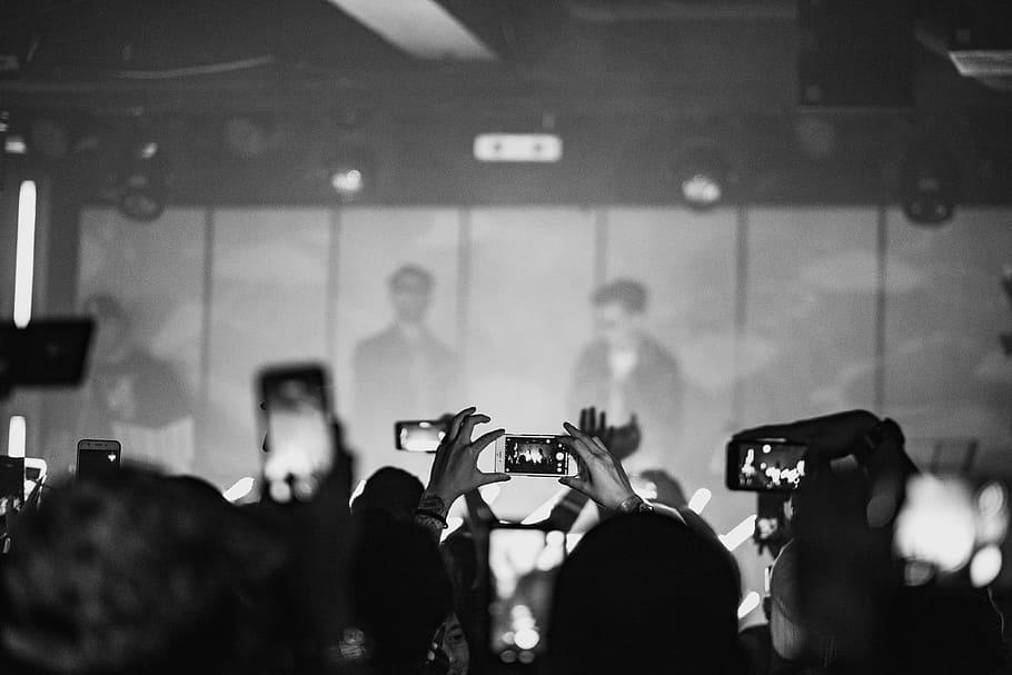 crowd taking photo of man wearing black sunglasses, grayscale concert photo HD wallpaper