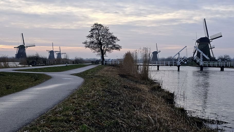windmill beside body of water, trees, road, farm, clouds, sky HD wallpaper