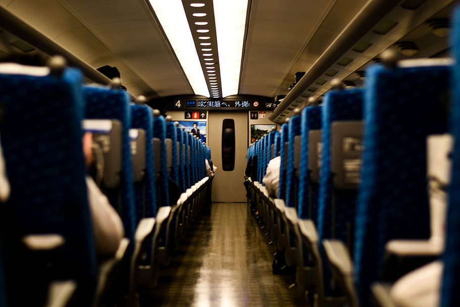 group of people sitting on passenger seat, selective focus photography of train chairs