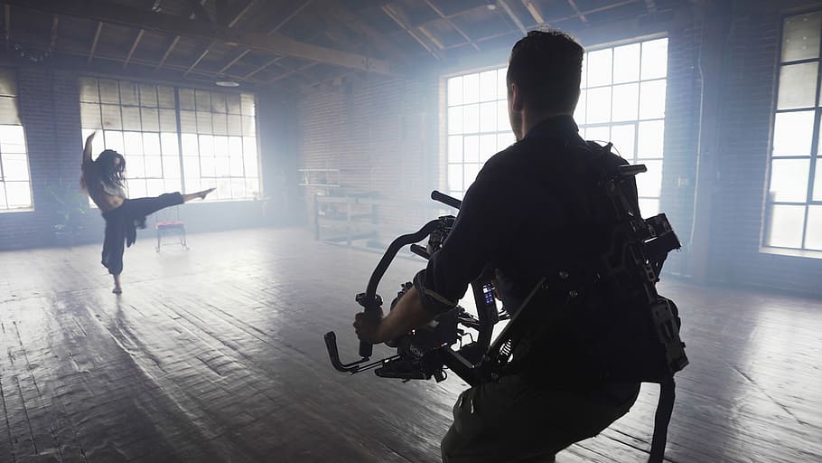 man using video camera shooting woman dancing inside room, man holding video camera shooting woman dancing HD wallpaper