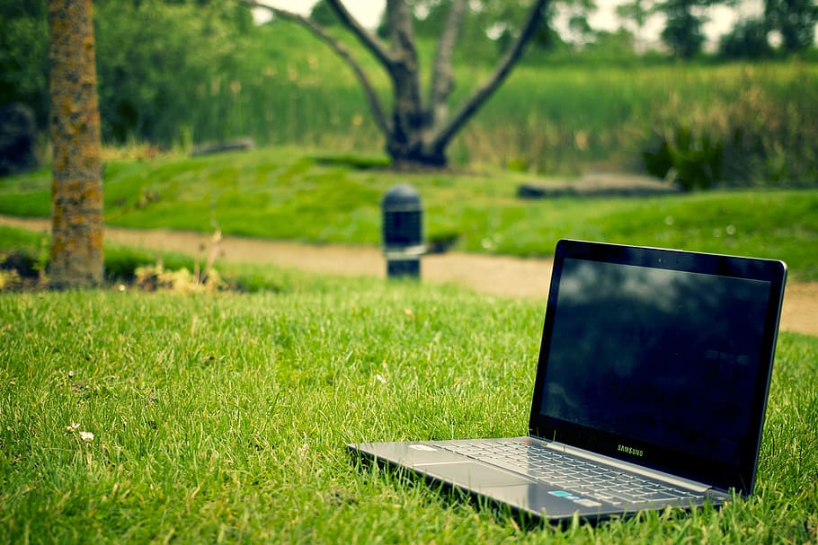 turned off black laptop computer on green grass field, notebook HD wallpaper