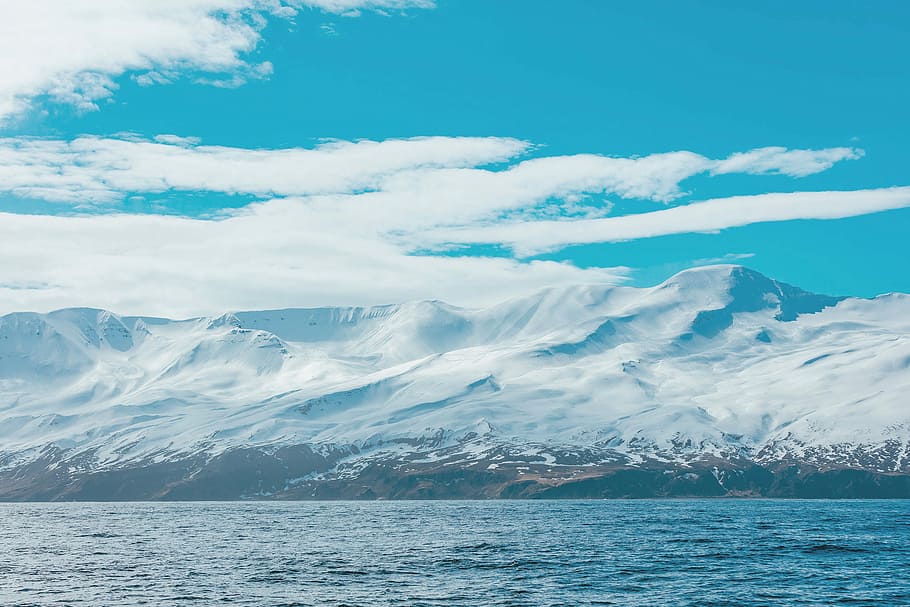 mountain covered with snow under white clouds, snow covered mountain near ocean HD wallpaper