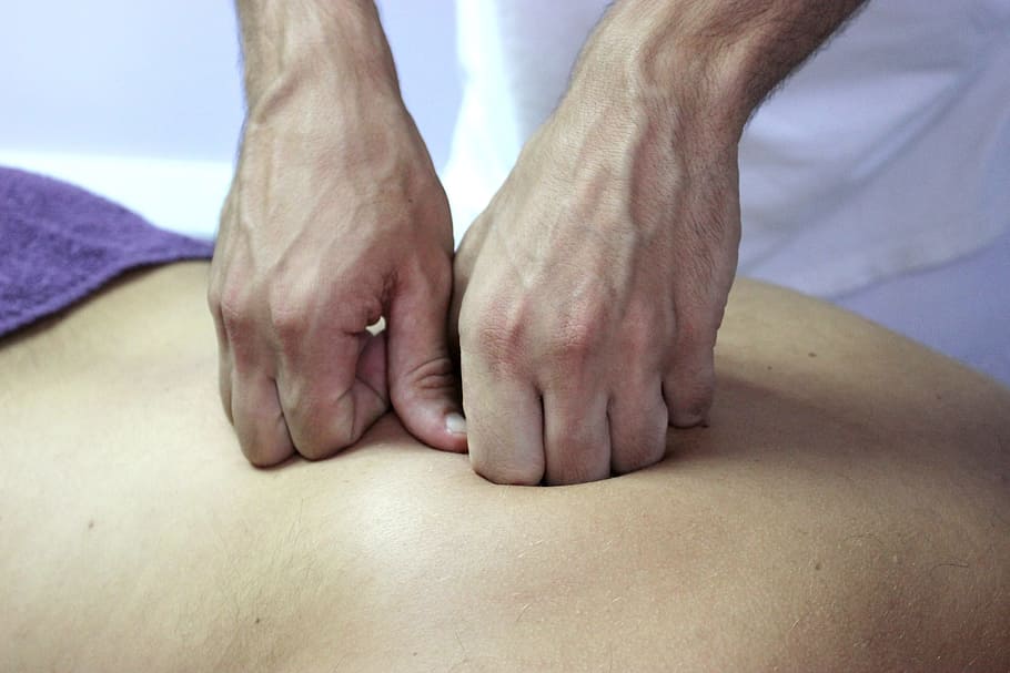 close-up photography of person massaging human back, Wellness