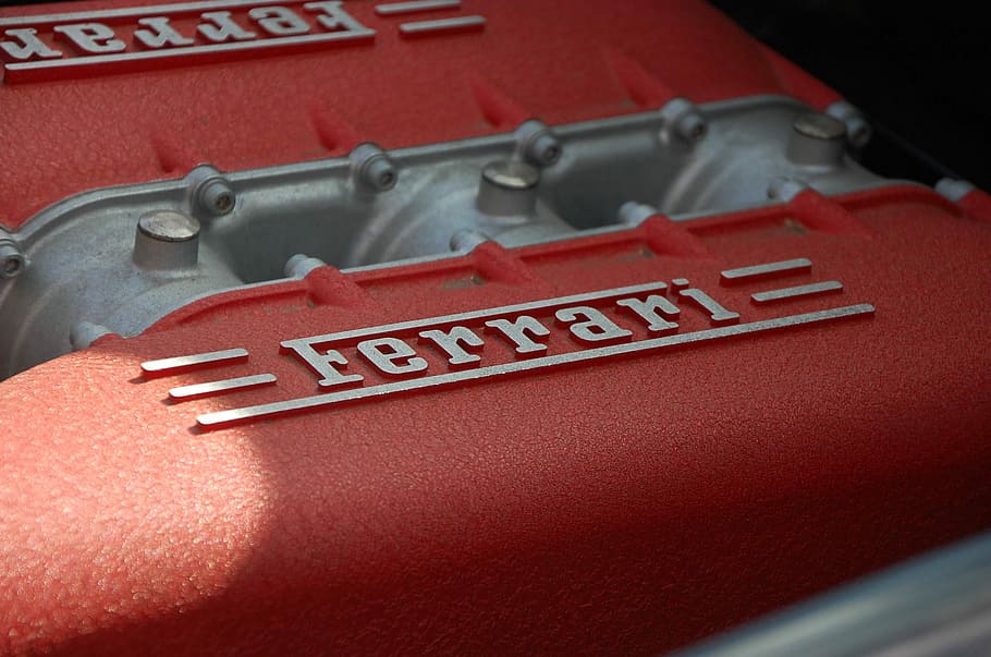 close-up photography of gray and red Ferrari engine, close view of red Ferrari case HD wallpaper