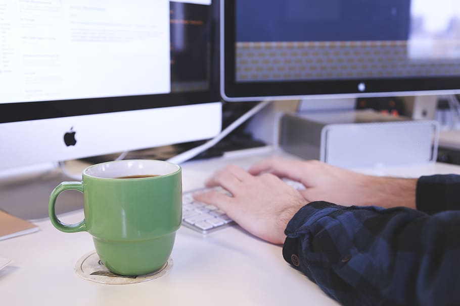 green ceramic mug on top of white coaster near person hand holding Apple Keyboard HD wallpaper