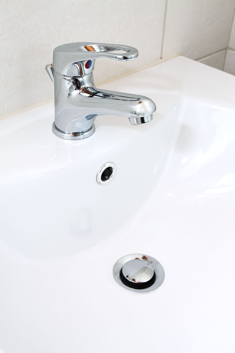 close up photo of white ceramic sink with stainless steel faucet