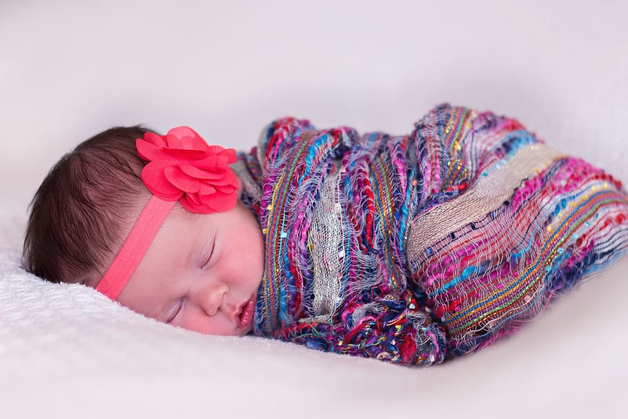 baby sleeping wearing multicolored blanket and red flower headband in closeup photography, HD wallpaper