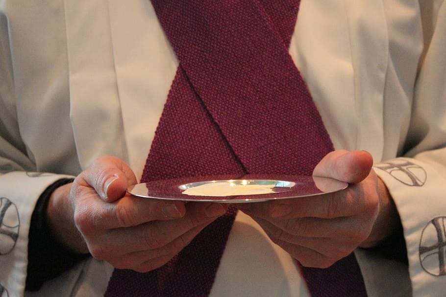 person holding saucer, holy communion, although, priest, communion wafers