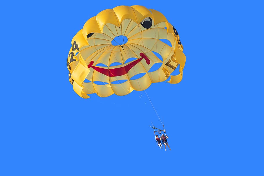 two person in yellow, red, and black parachute under blue sky during daytime, two persons paragliding HD wallpaper