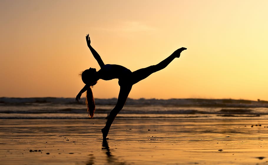 Ashi Ross in Huntington Beach, woman doing ballerina pose near sea