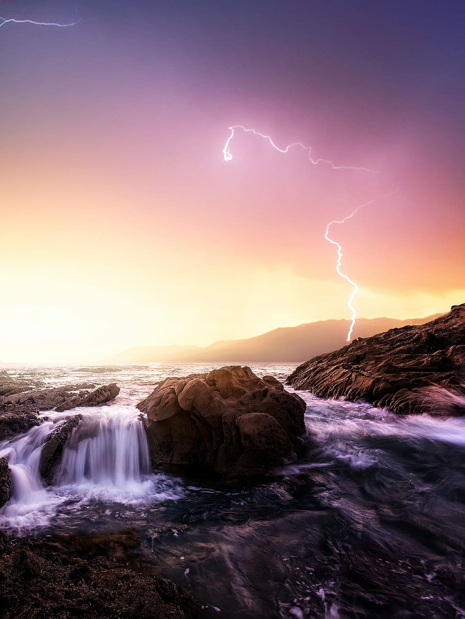 rock formation near sea under thunder light, timelapse photography of cascading waterfalls HD wallpaper