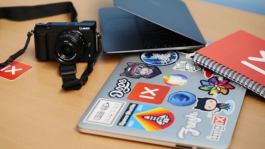 black DSLR camera, black DSLR camera near MacBook and books, laptop HD wallpaper