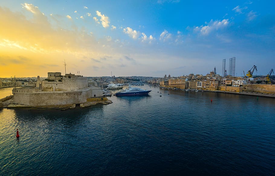 ship on ocean near houses during daytime, malta, harbor, sunrise
