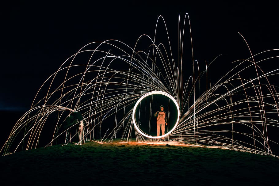 time lapse photo of person on shore, fire dancing still wool photography