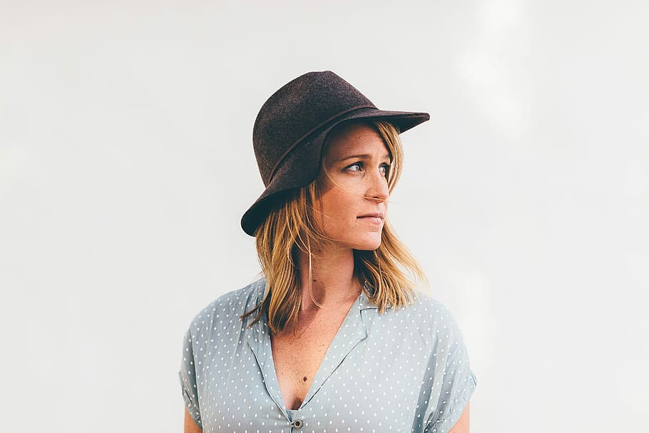 photo of woman wearing black bucket hat and beige v-neck top with white background HD wallpaper