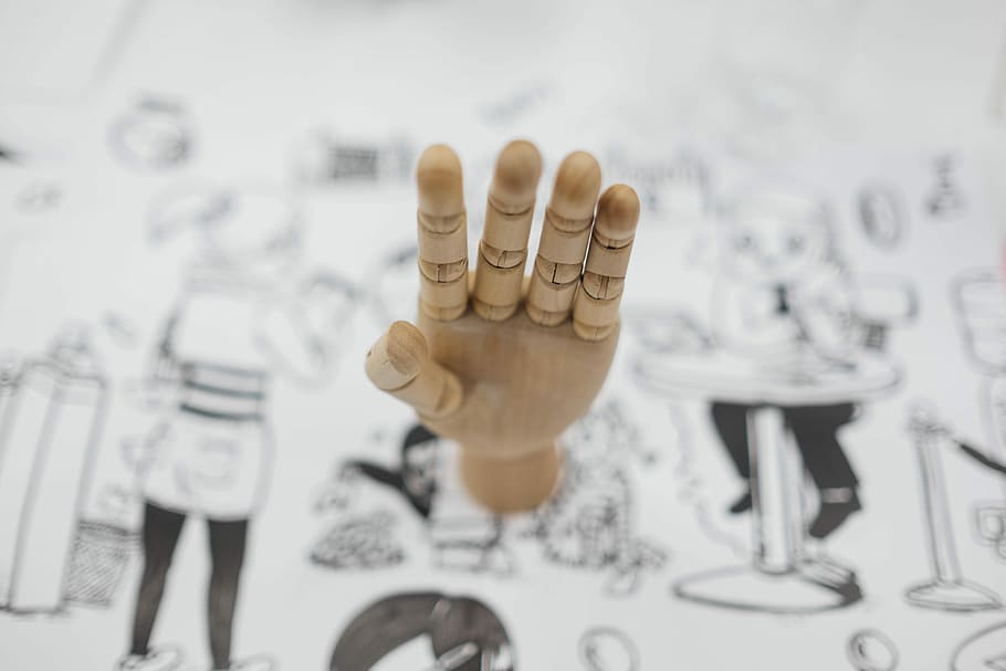 artist dummy hand on white paper, selective focus photography of puppet hand HD wallpaper