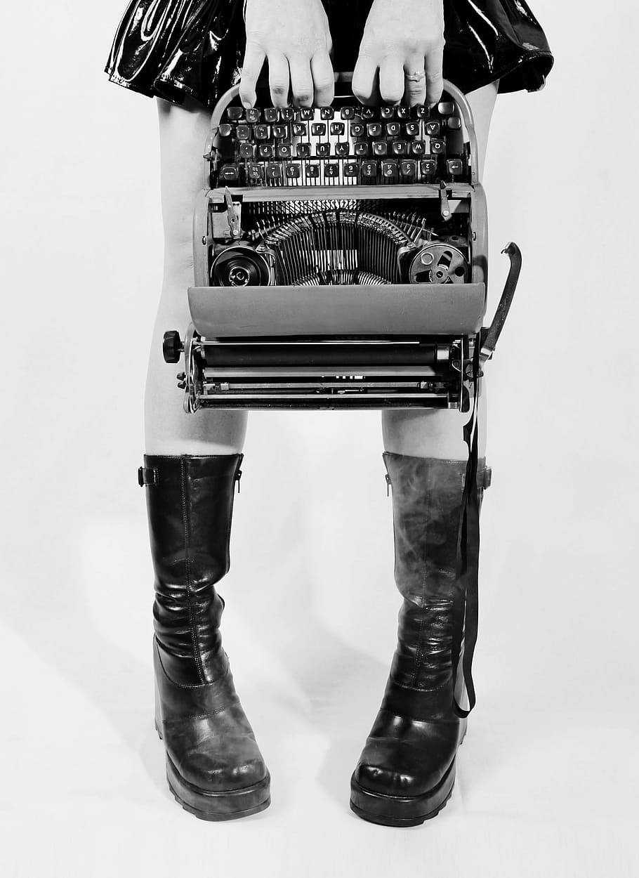 grayscale photograph of person holding type writer machine HD wallpaper