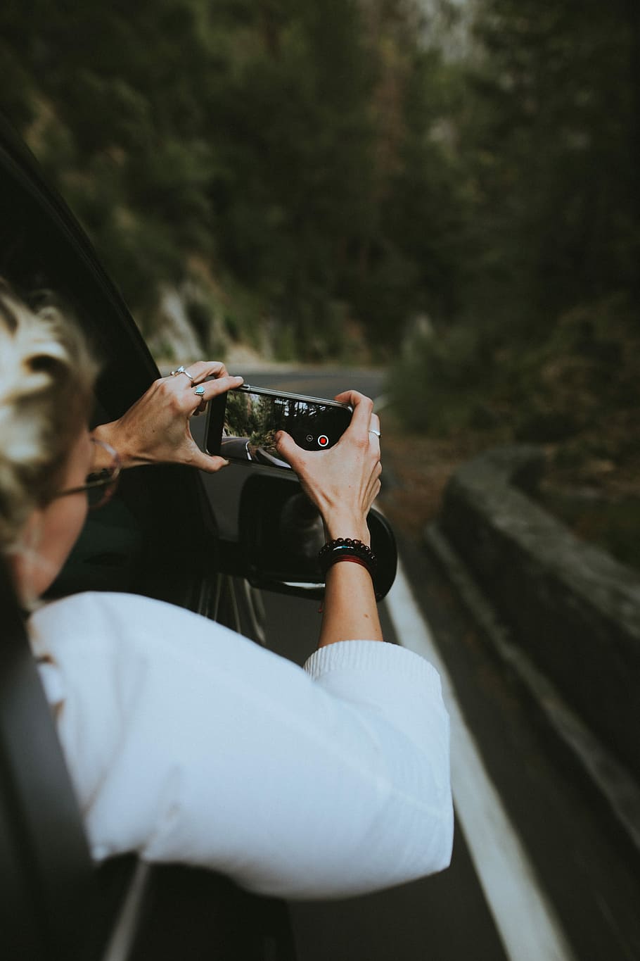 woman riding on the car holding smartphone taking a picture, untitled, HD wallpaper