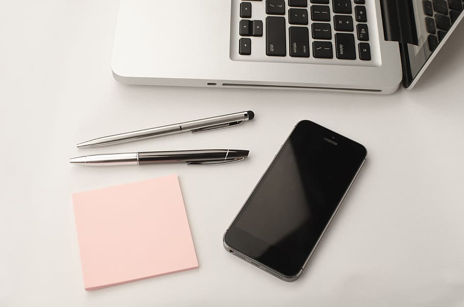 iPhone 6 beside MacBook on white surface, laptop, apple, keyboard HD wallpaper