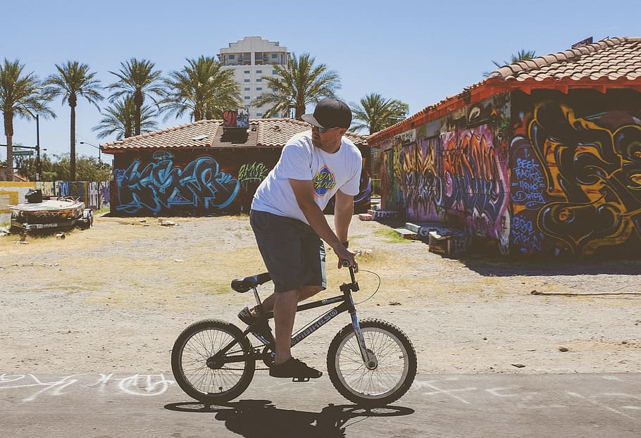 man using black BMX bicycle, man in white crew-neck t-shirt riding black BMX bike during daytime, HD wallpaper