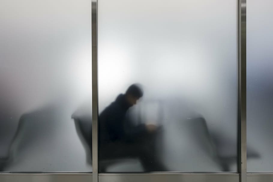 silhouette of man behind frosted glass window, airport, passenger