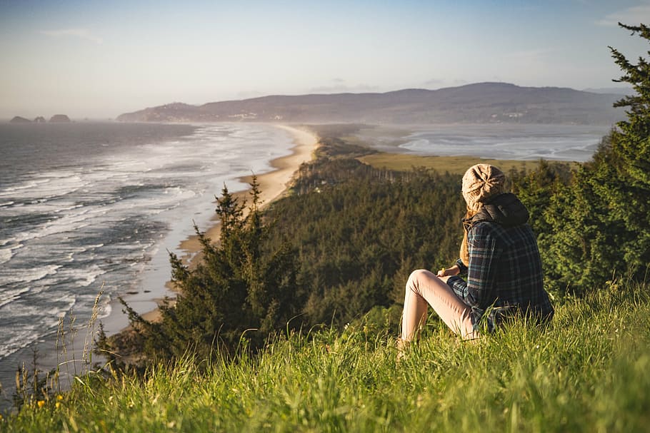 woman sitting on green grass facing on body of water, beach HD wallpaper