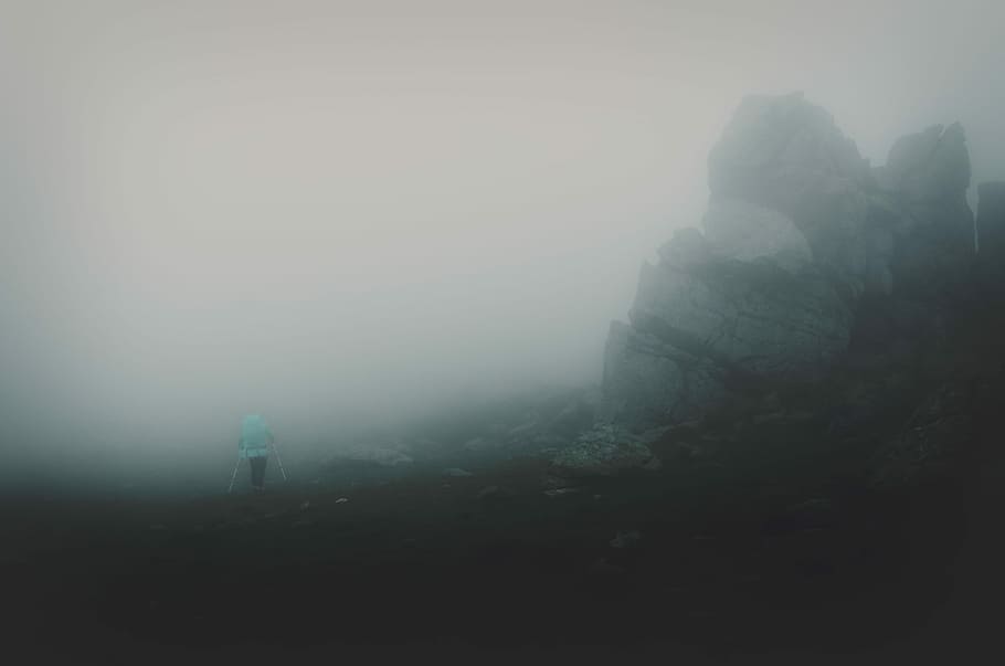person standing beside gray rock formation, person hiking on mountain HD wallpaper