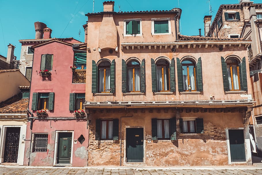 closeup photography of brown concrete 3-storey building, orange concrete building beside red concrete building HD wallpaper