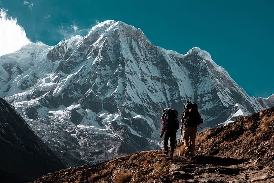 two person hiking, two person hiking on mountain under blue sky