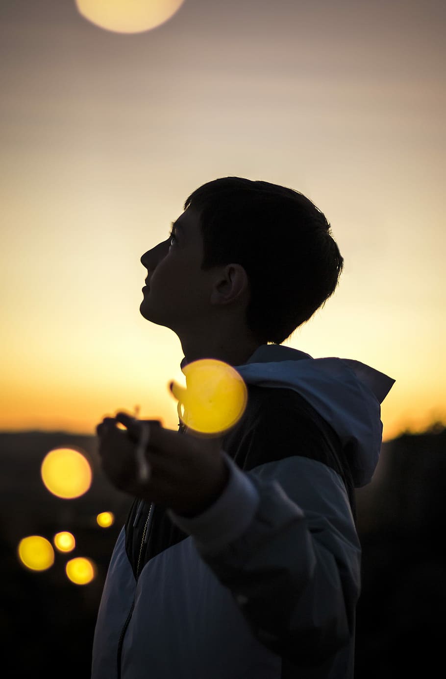 selective focus photography of person spread arms under golden hour, boy with white and black zip-up hooded windbreaker jacket during golden hour