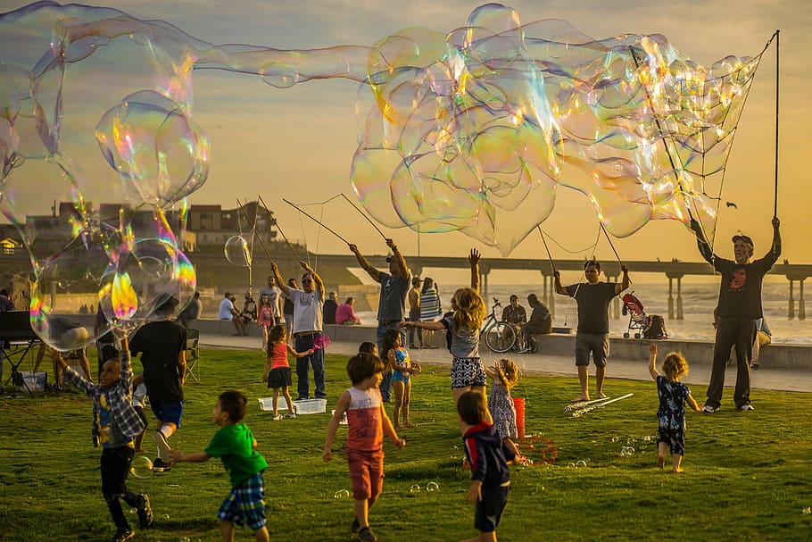 group of people playing with bubbles, party, kids, jumping, fun