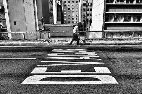 gray scale photography of person walking beside pave road, grayscale photography of man walking beside road HD wallpaper