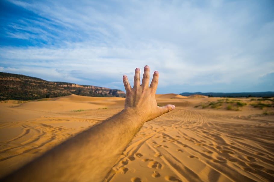 left human hand about to reach sand and sky, person left hand reaching desert mountain HD wallpaper