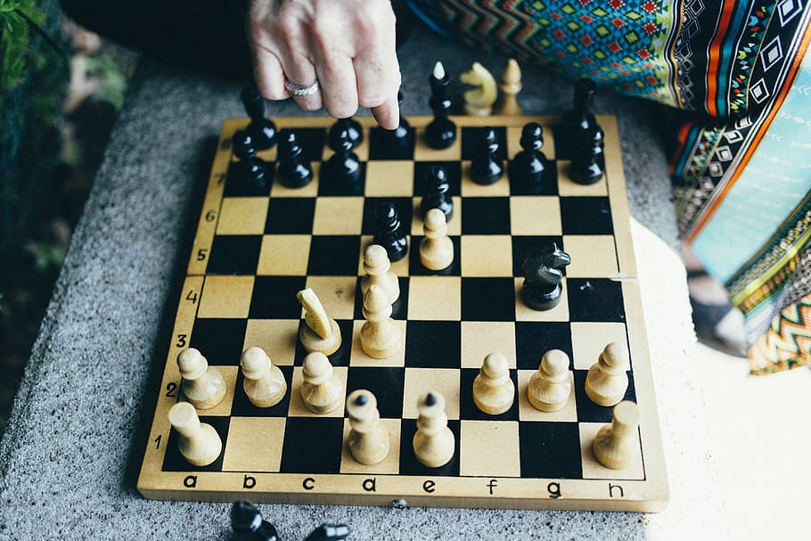 person playing chess, game of chess photo during daytime, board HD wallpaper