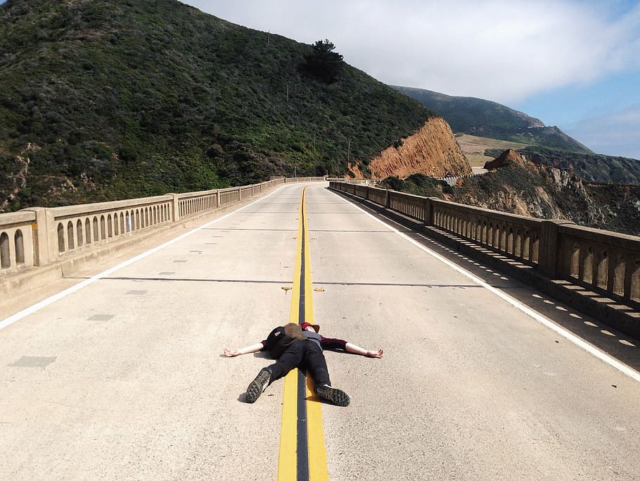 person lying on bridge at daytime, wearing, backpack, cloudy HD wallpaper