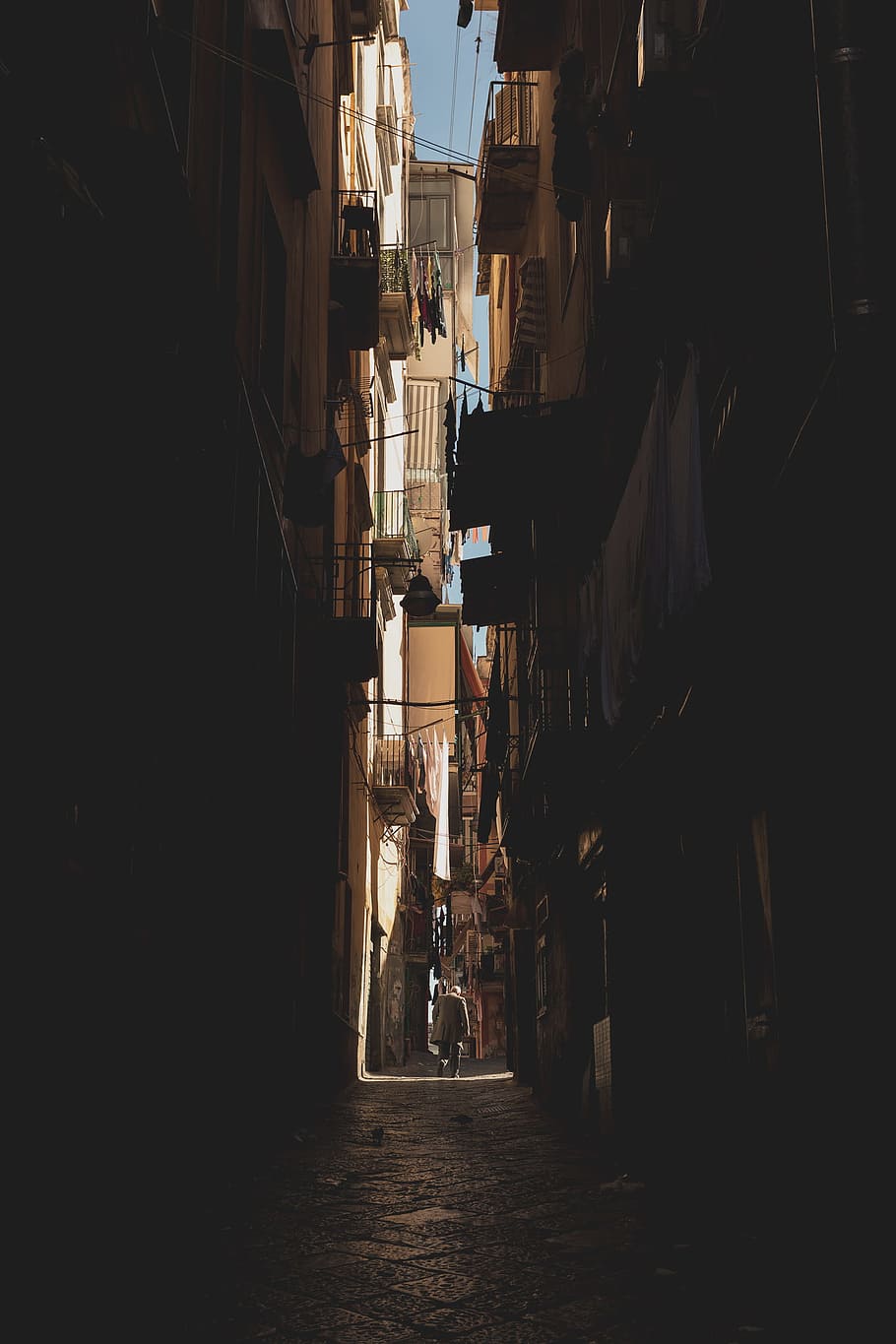 person walking in middle of buildings, man walking at the alley HD wallpaper