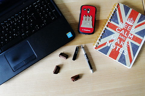 laptop on table beside phone, pen, and notebook, mobile phone HD wallpaper