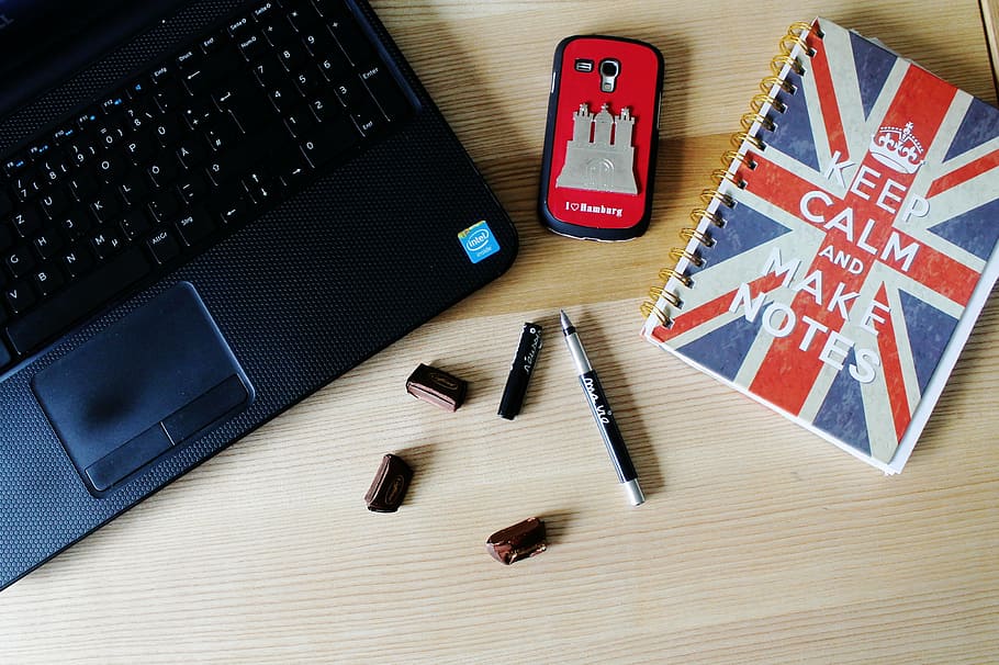laptop on table beside phone, pen, and notebook, mobile phone HD wallpaper